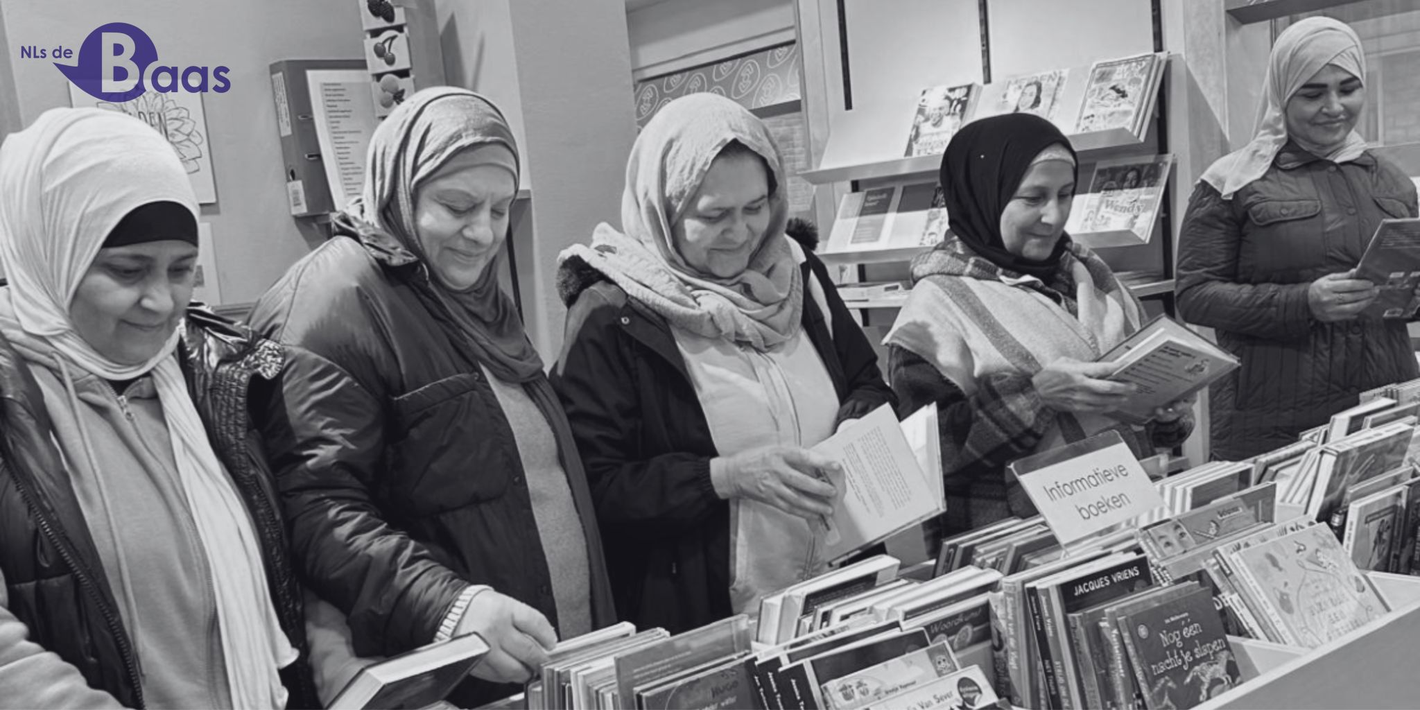 Deelnemers bekijken samen boeken tijdens een bezoek aan de bibliotheek in Hatert