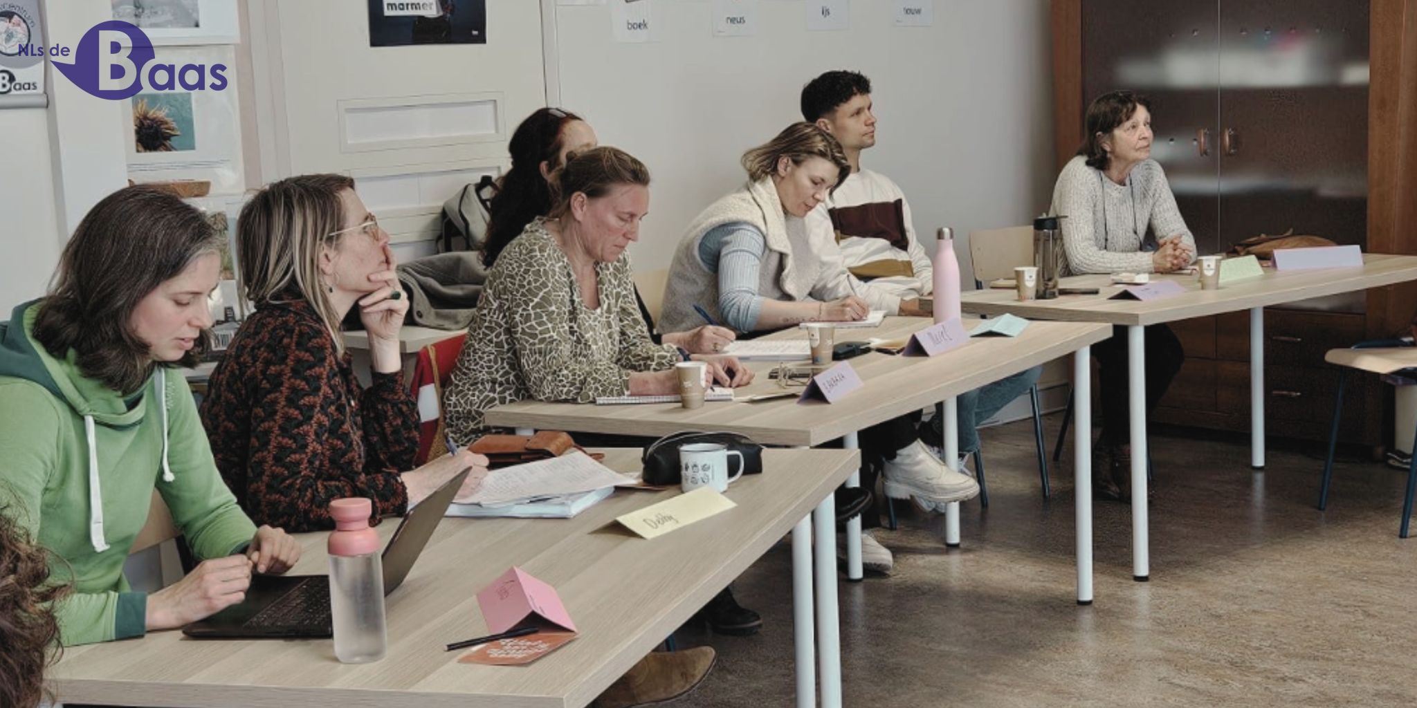 Deelnemers en begeleiders werken samen aan een creatieve opdracht