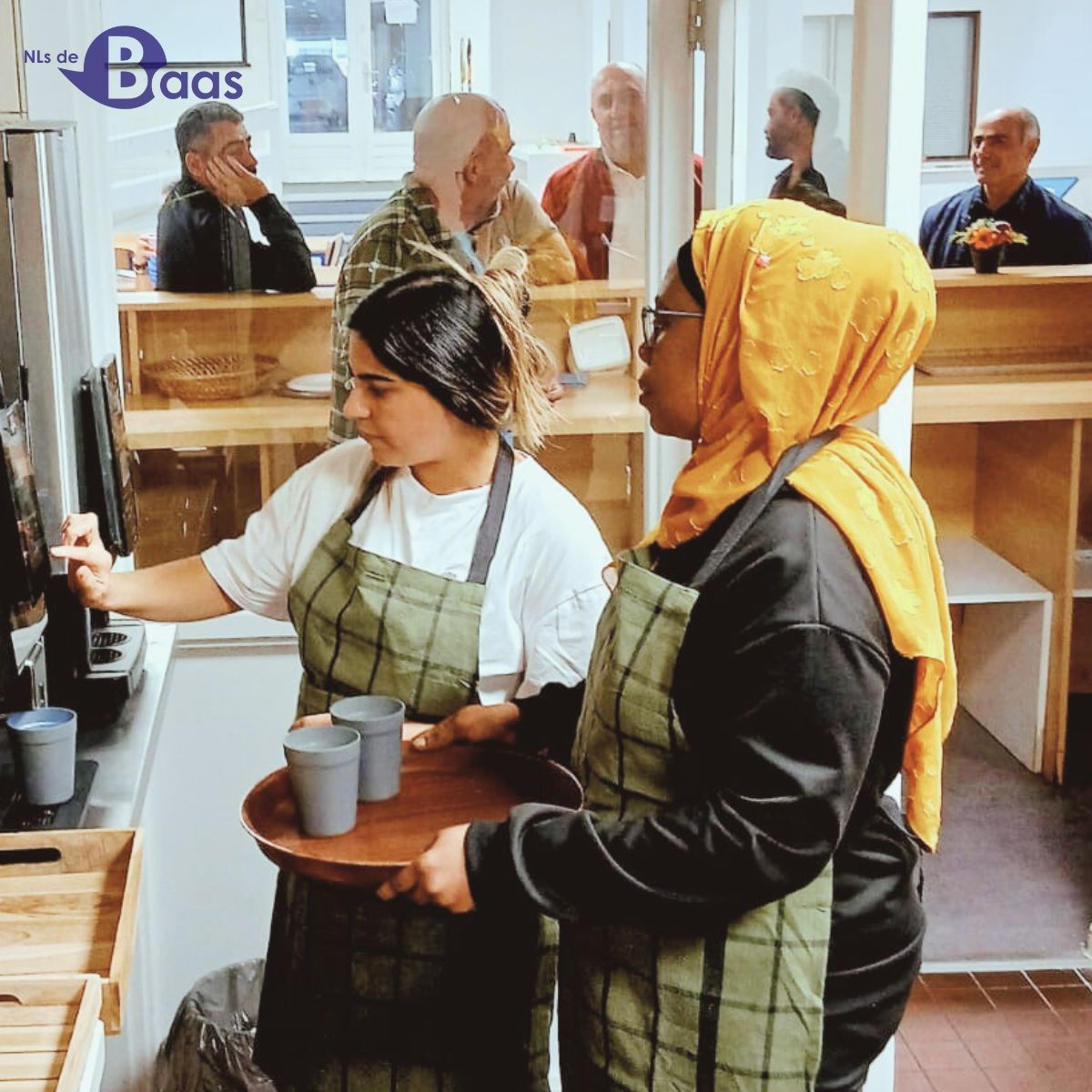 Deelnemers serveren koffie en thee tijdens de opening van de keuken op locatie Arnhem